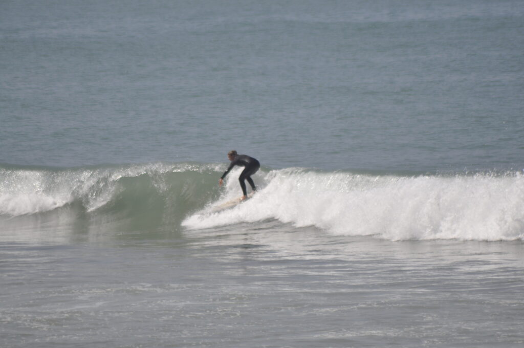 Experienced surfer riding a wave in Tamraght – Compare the best surf spots in Taghazout and Tamraght with our guide