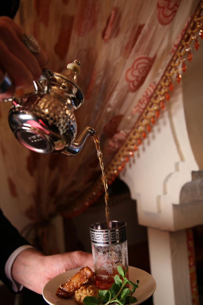 Sipping on a refreshing glass of Moroccan mint tea – the perfect drink to complement your meal.
